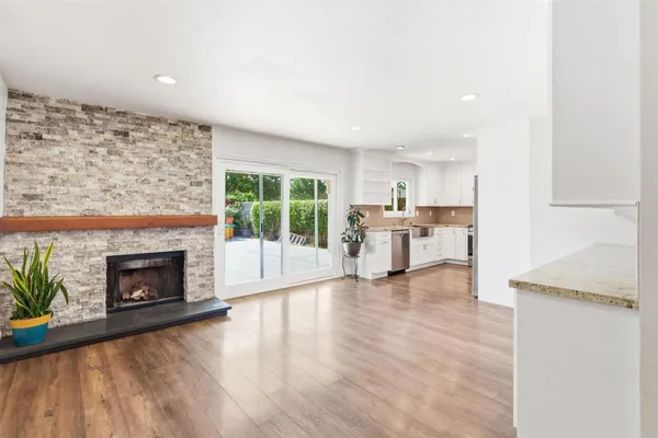 a kitchen with granite countertop white cabinets and refrigerator