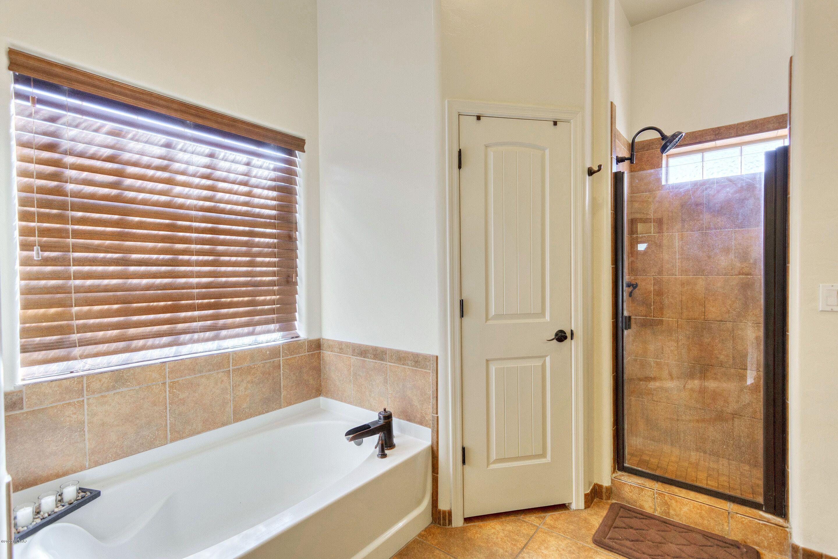 928 Paseo Cieneguita Rio Rico, AZ 85648 - Photo 19 of 27 a bathroom with a bathtub and a shower