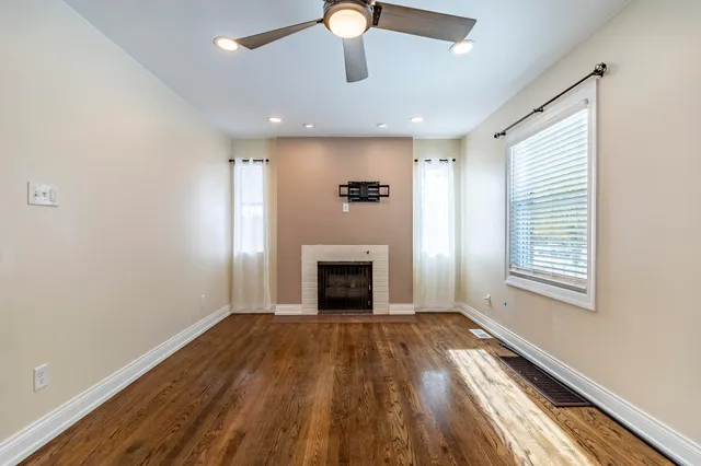 a view of an empty room with a fireplace and a window