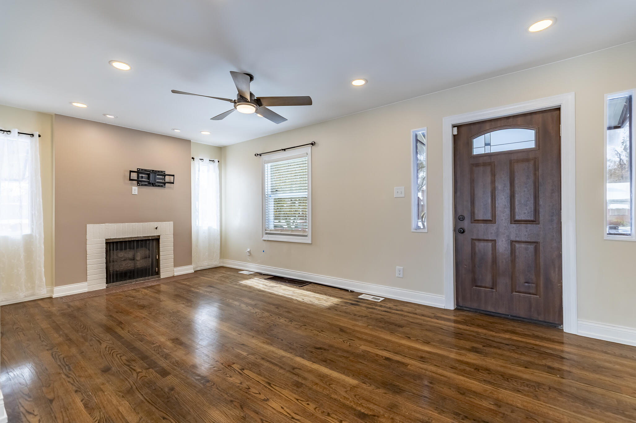 1035 Willard Street Gary, IN 46404 - Photo 12 of 30 an empty room with windows fireplace and a kitchen view