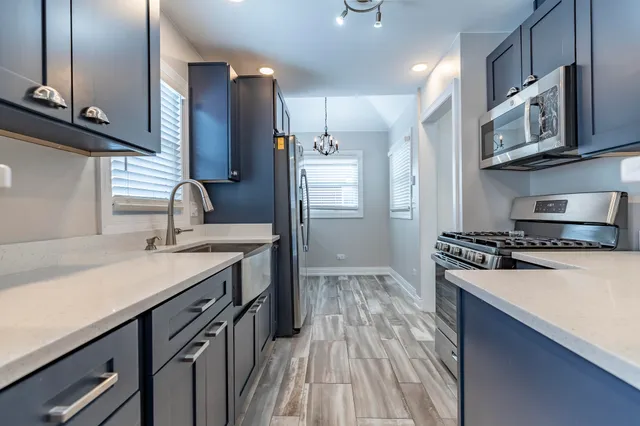 a kitchen with stainless steel appliances granite countertop a sink stove and refrigerator