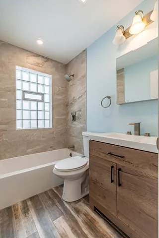 a bathroom with a sink toilet a mirror and bathtub