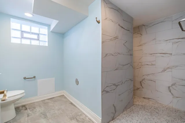 a bathroom with a toilet and a shower