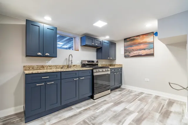 a kitchen with granite countertop a stove a sink and a refrigerator