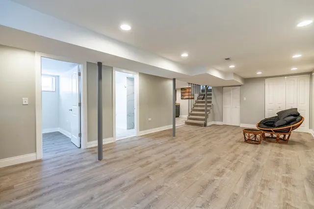 a view of an empty room with wooden floor and windows