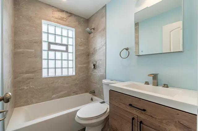 a bathroom with a bathtub shower sink vanity and toilet