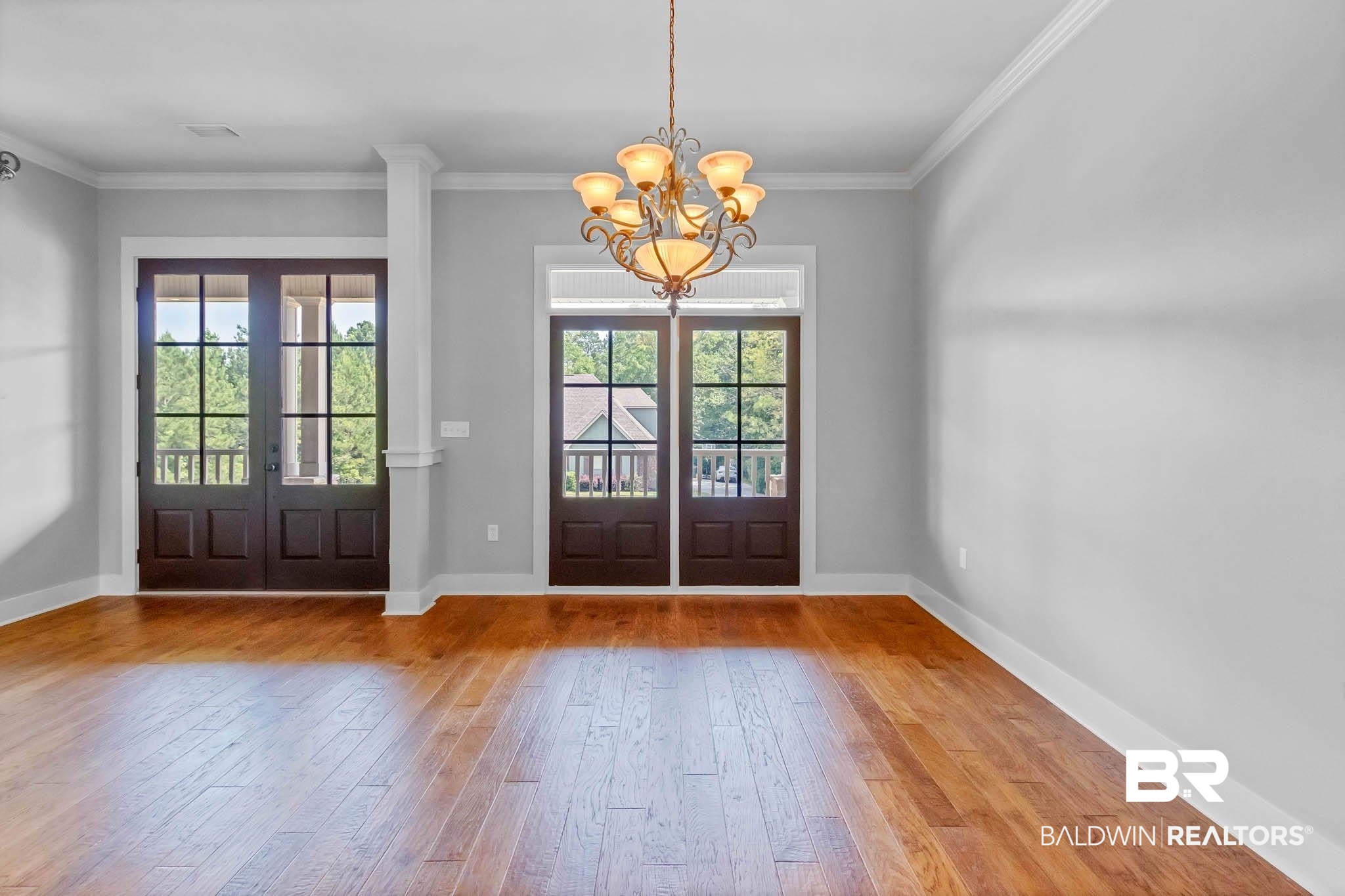7854 Raegan Lane Daphne, AL 36527 - Photo 30 of 70 Dining area featuring wood-type flooring, plenty of natural light, a chandelier, french doors, and crown molding