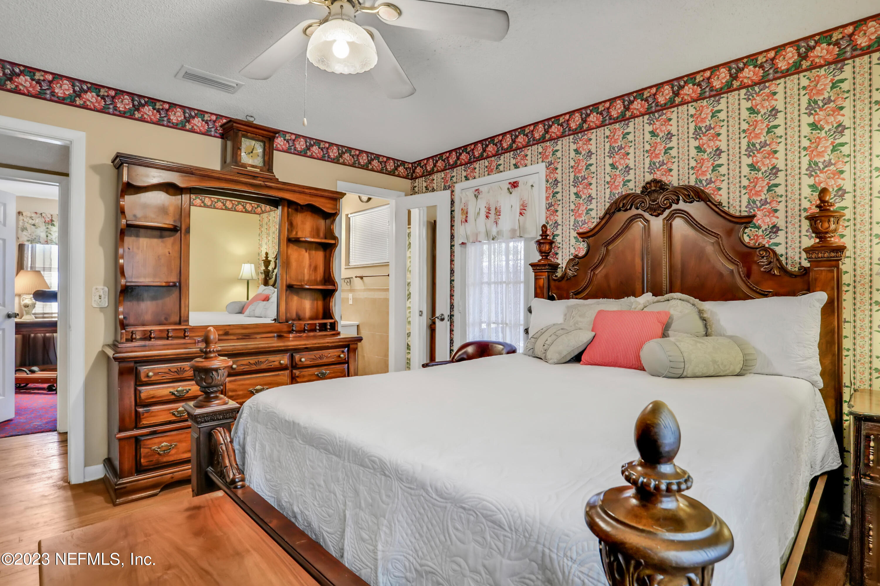 6853 Merrill Road Jacksonville, FL 32277 - Photo 13 of 36 a bedroom with a bed and wooden floor