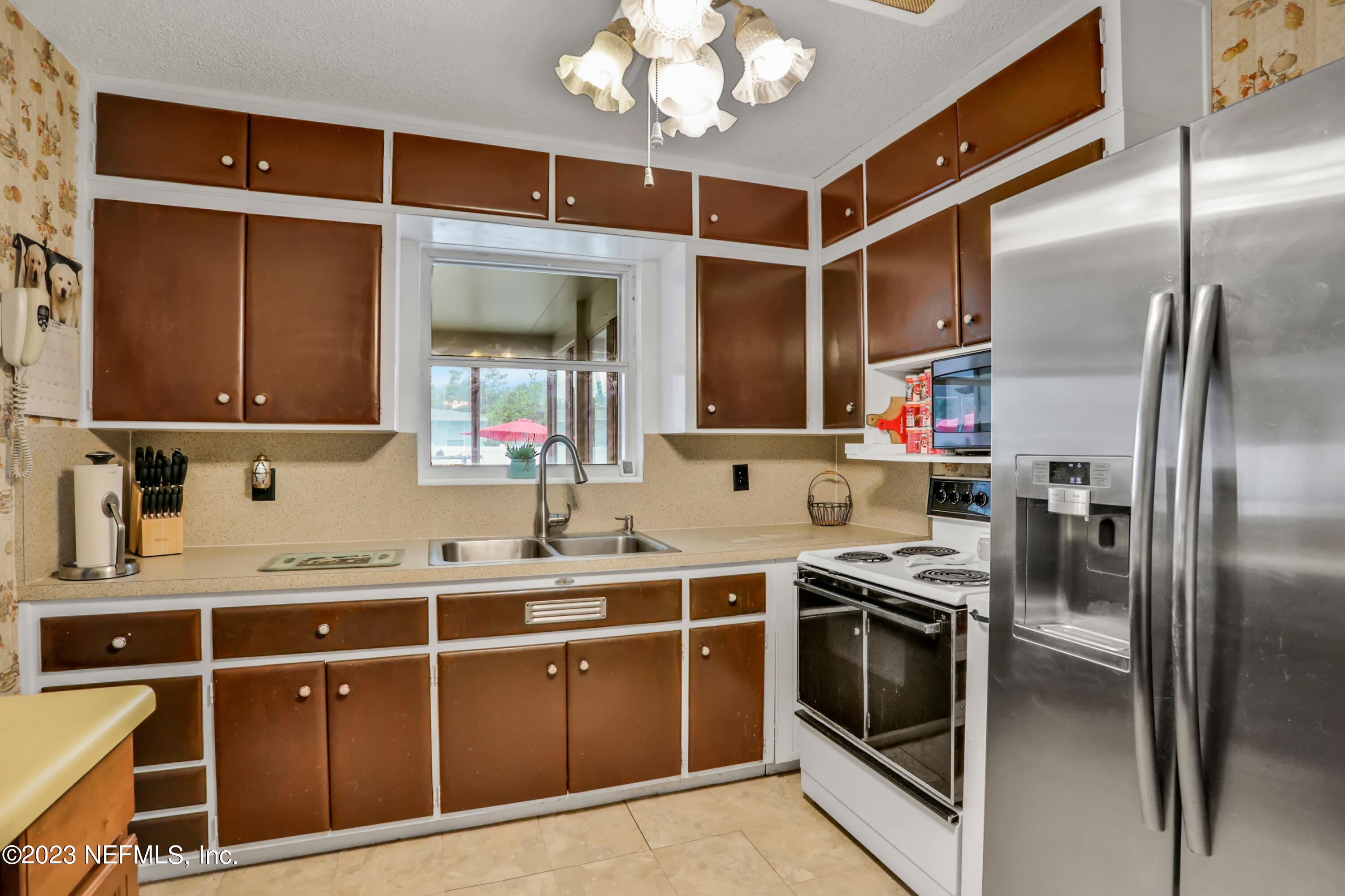 6853 Merrill Road Jacksonville, FL 32277 - Photo 23 of 36 a kitchen with stainless steel appliances granite countertop a sink a stove and a refrigerator