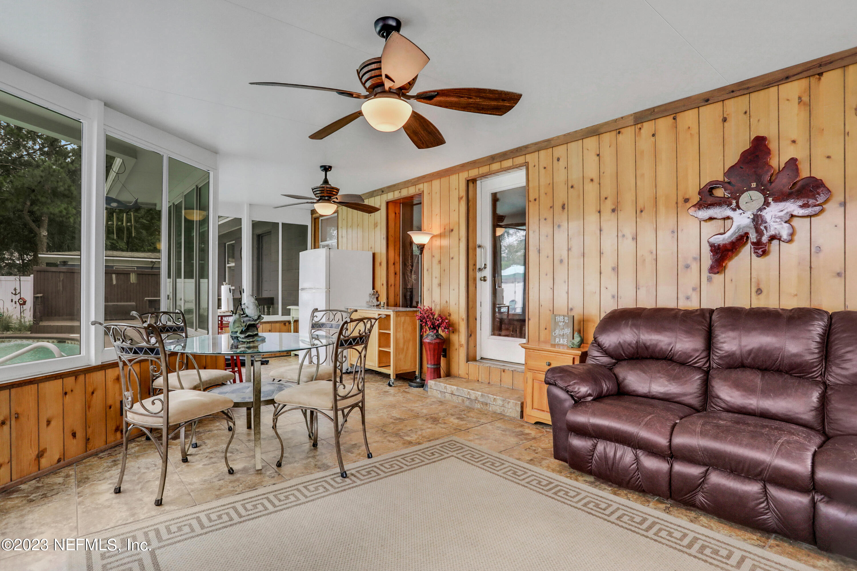 6853 Merrill Road Jacksonville, FL 32277 - Photo 29 of 36 a living room with furniture ceiling fan and a large window