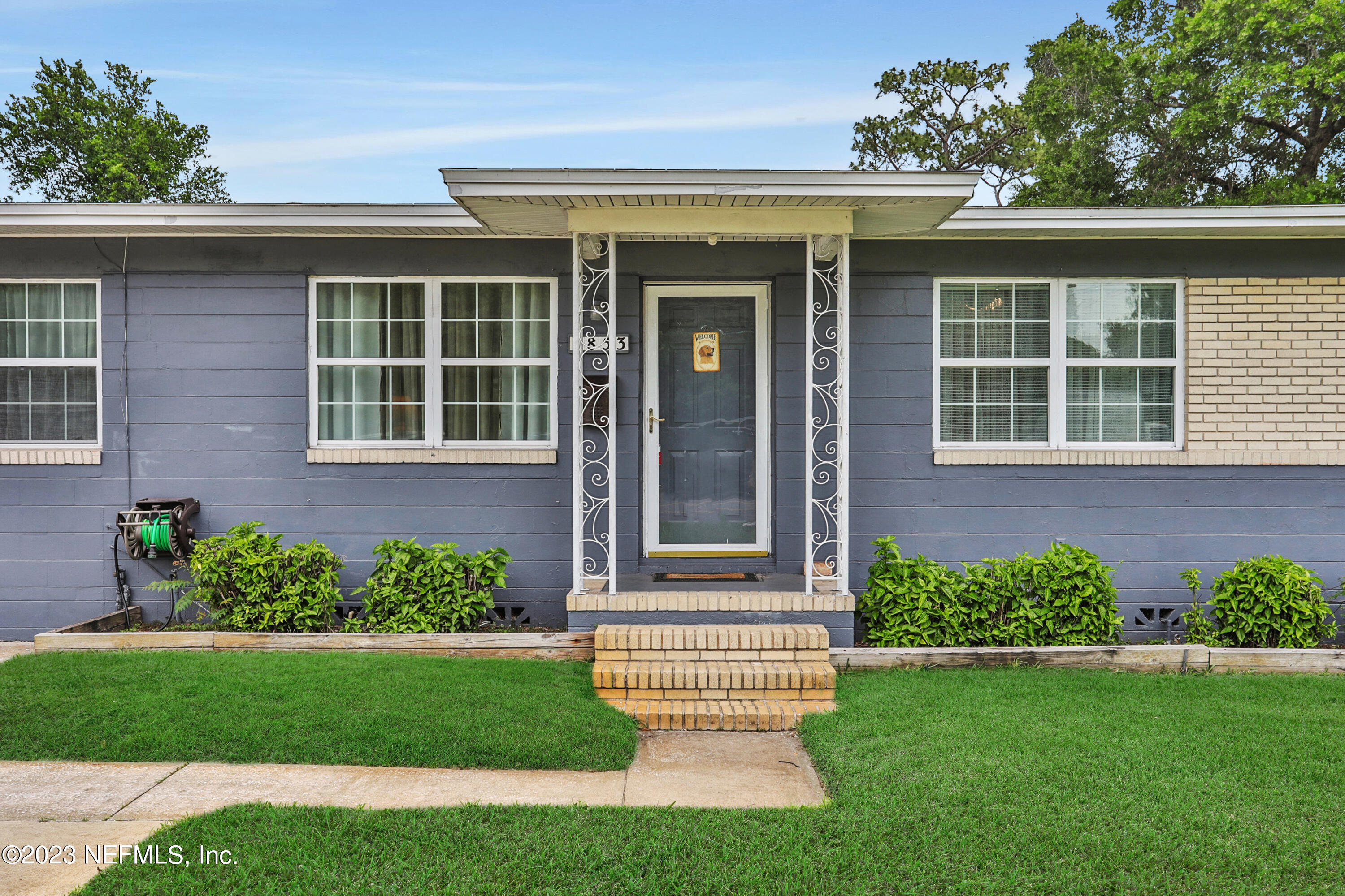 6853 Merrill Road Jacksonville, FL 32277 - Photo 3 of 36 a front view of a house with a yard