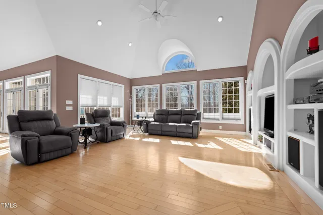 a view of an empty room with window and wooden floor