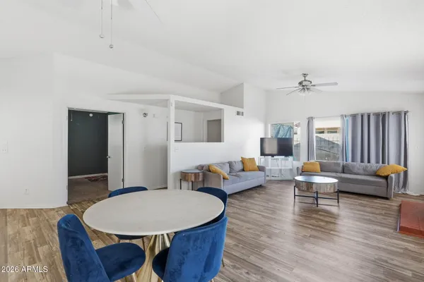 a living room with furniture a table and wooden floor