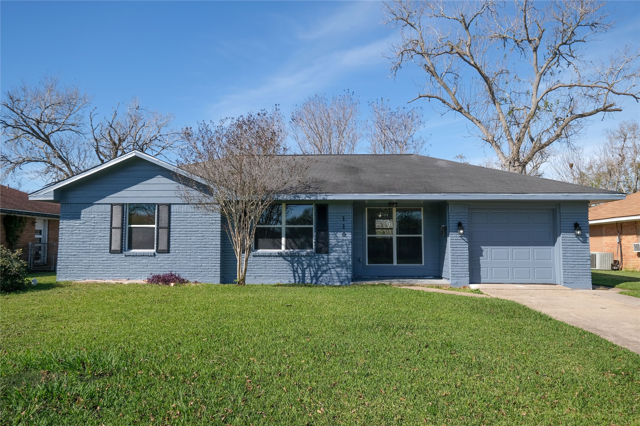 a view of a house with a yard and large tree