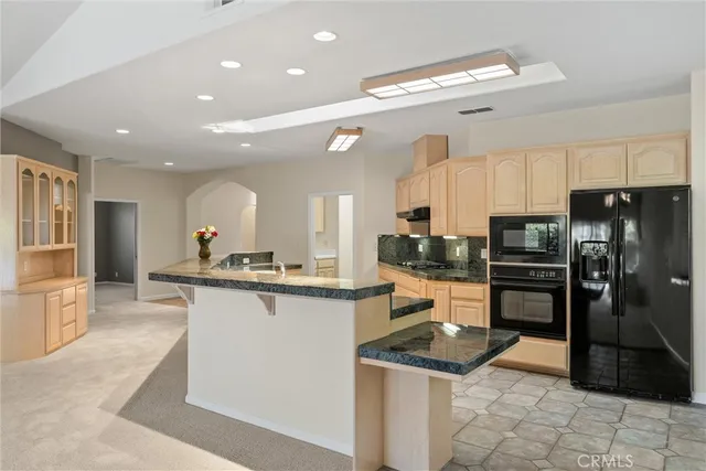 a large kitchen with stainless steel appliances granite countertop a stove and a sink