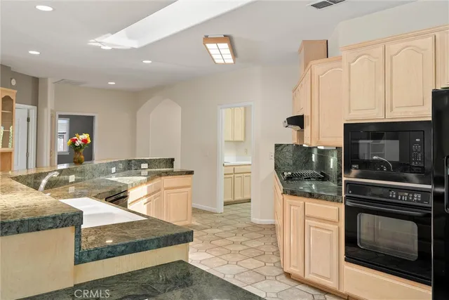 a kitchen with stainless steel appliances granite countertop a sink and a stove
