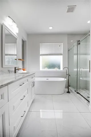 a bathroom with a tub a sink and mirror