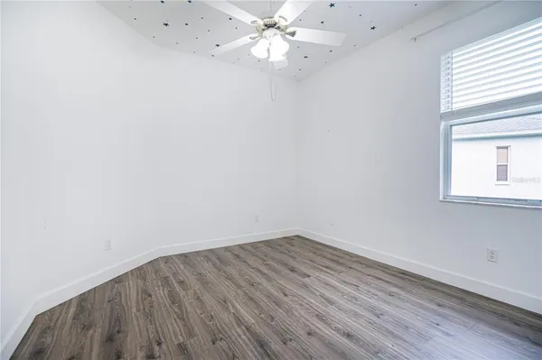 an empty room with a window and wooden floor