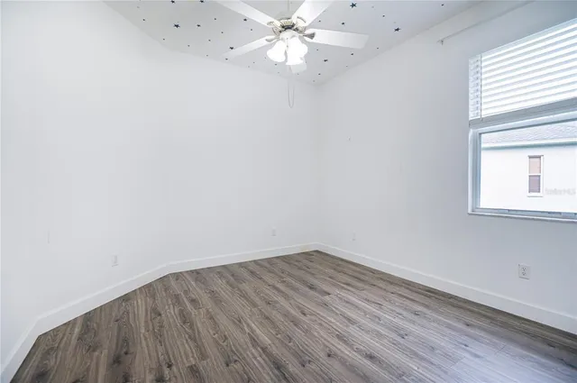 an empty room with a window and wooden floor