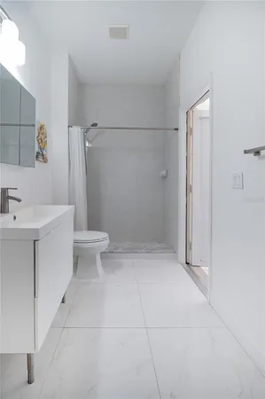 a bathroom with a sink a toilet and shower
