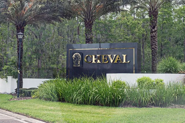 a view of sign board with yard and trees