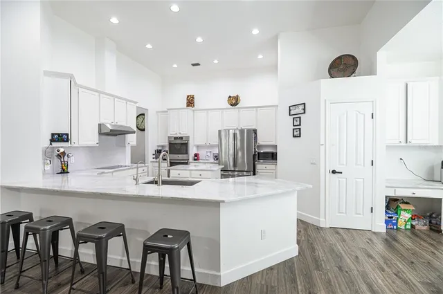 a kitchen with stainless steel appliances granite countertop a sink and a refrigerator
