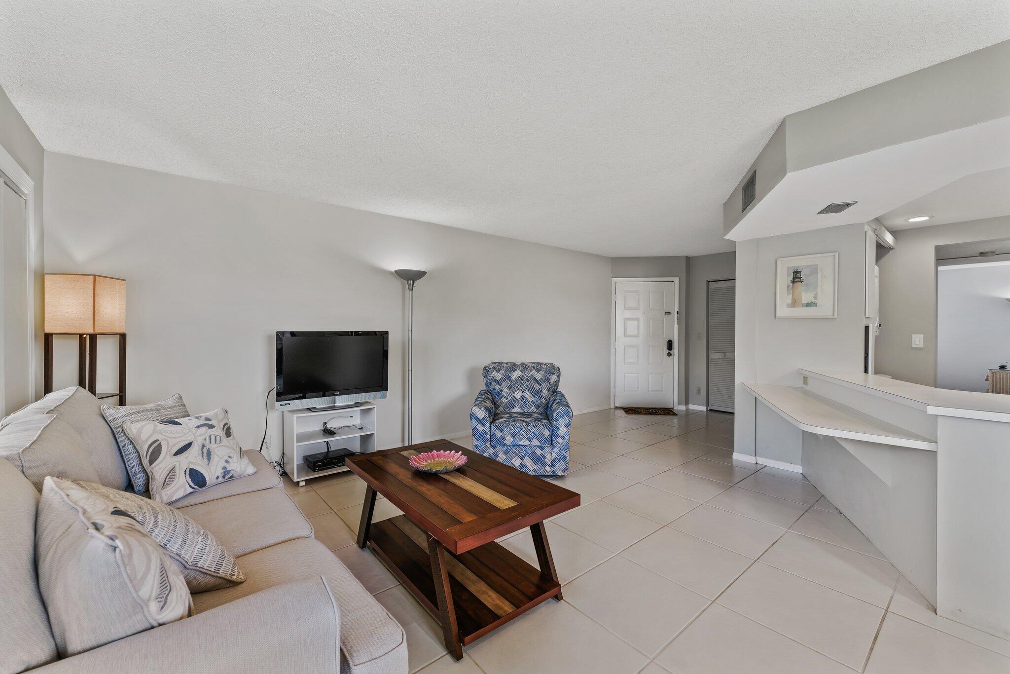 1605 Highway 1, Unit D301 Jupiter, FL 33477 - Photo 11 of 46 a living room with furniture a flat screen tv and a fireplace