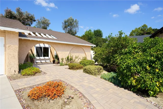 a view of a house with potted plants in front of door