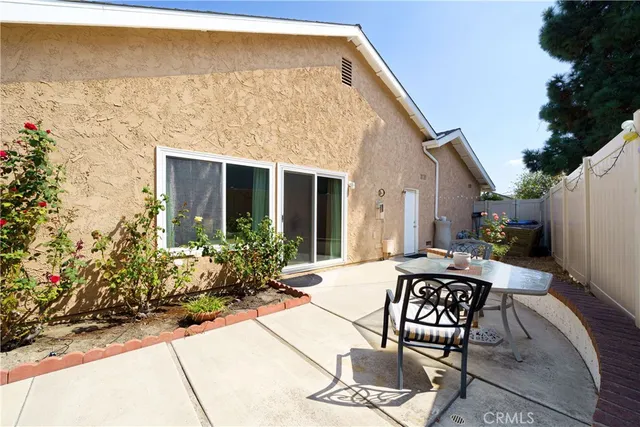 a view of a patio with chair and tables back yard of the house