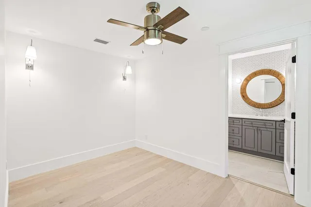 an empty room with a ceiling fan and a window