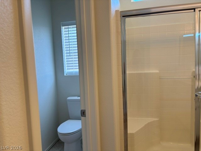 2866 Shimmering Bay Street Laughlin, NV 89029 - Photo 17 of 32 A well-appointed bathroom with a windowed toilet nook and a tiled shower stall.