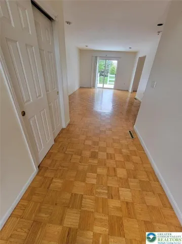 a view of empty room with wooden floor