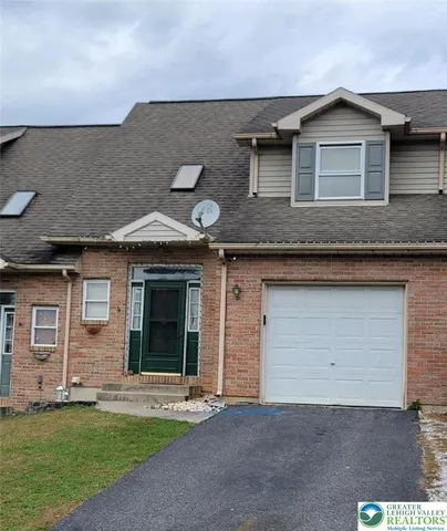 a front view of a house with a garden and yard