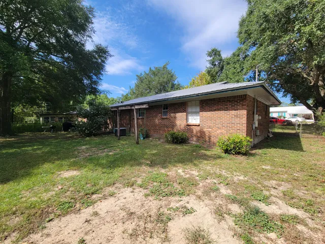 a front view of house with yard and trees