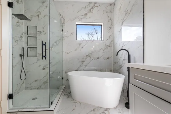 a white bath tub sitting next to a shower