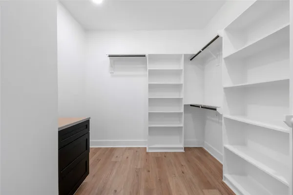 a view of walk in closet with empty racks