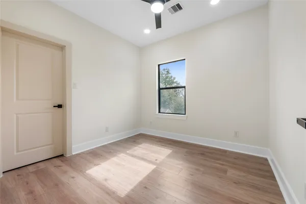 an empty room with windows and cabinet