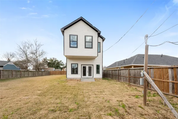 a view of a house with a small yard and wooden fence