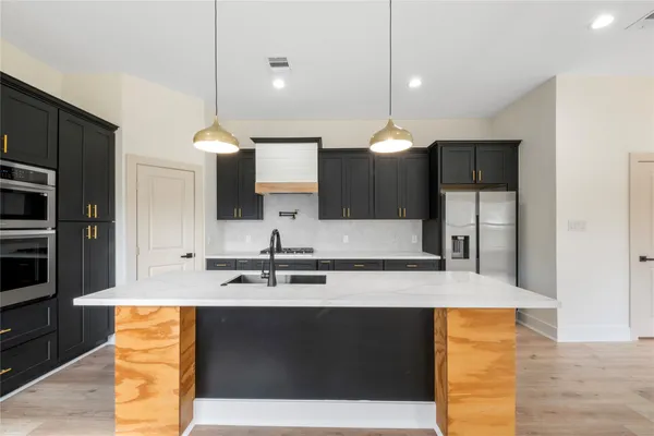 a kitchen with kitchen island granite countertop a sink and cabinets