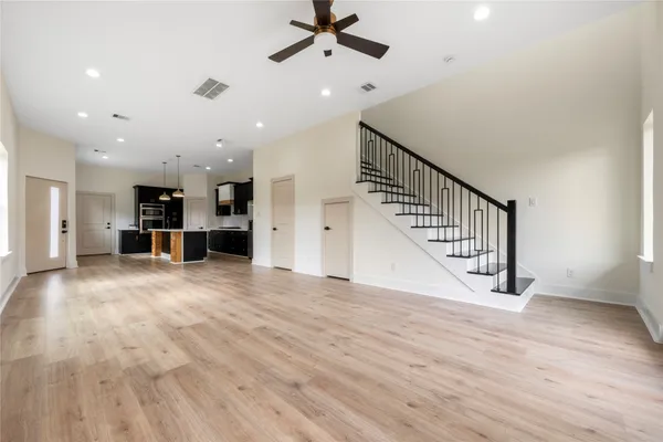 a view of a livingroom with wooden floor and staircase