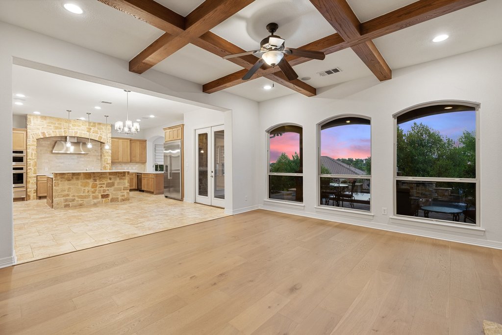109 Largo Cove Austin, TX 78734 - Photo 6 of 40 Exposed beams adorn the vaulted ceilings above the sun-drenched living space and stone-clad gourmet kitchen.