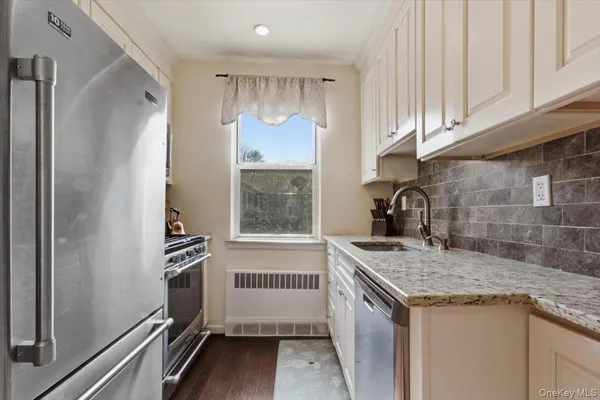 a kitchen with granite countertop a sink stove and refrigerator