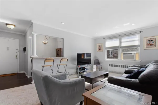 a living room with furniture a flat screen tv and a window
