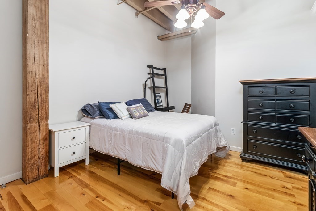 111 Beach Street, Unit 3D Boston, MA 02111 - Photo 7 of 10 a bedroom with a bed and a chandelier