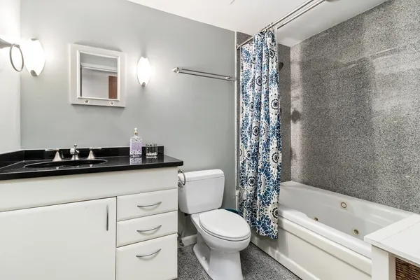 a bathroom with a sink a toilet a mirror and shower