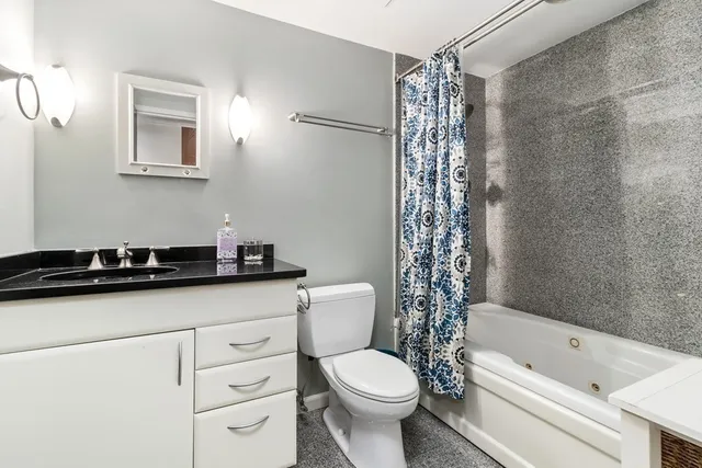 a bathroom with a sink a toilet a mirror and shower