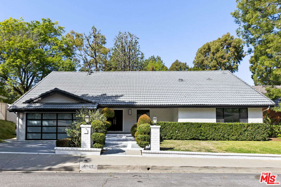 16167 Meadowcrest Road Sherman Oaks, CA 91403 - Photo 1 of 31 a front view of a house with garden