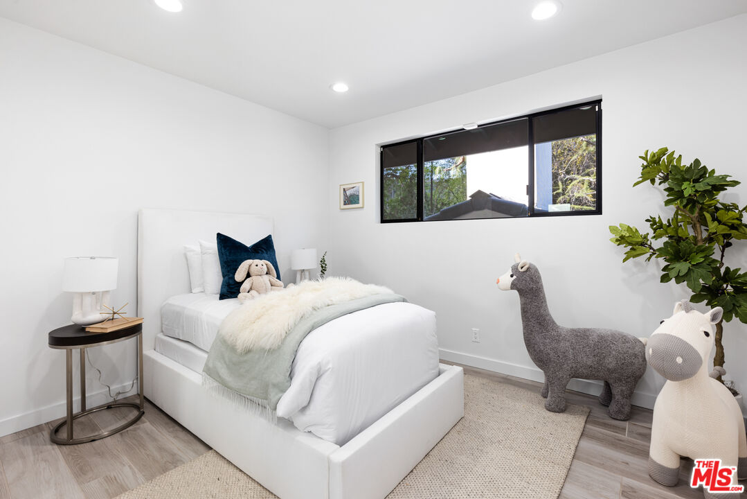 16167 Meadowcrest Road Sherman Oaks, CA 91403 - Photo 22 of 31 a bedroom with a bed and a potted plant