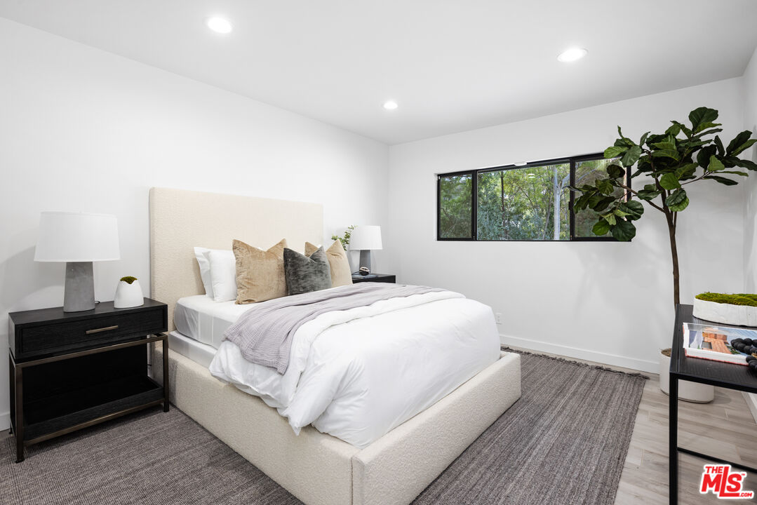 16167 Meadowcrest Road Sherman Oaks, CA 91403 - Photo 23 of 31 a bedroom with a bed and a potted plant