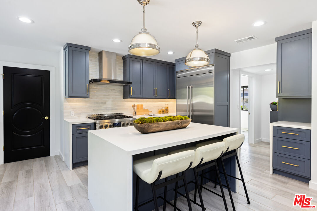 16167 Meadowcrest Road Sherman Oaks, CA 91403 - Photo 4 of 31 a kitchen with refrigerator cabinets dining table and chairs